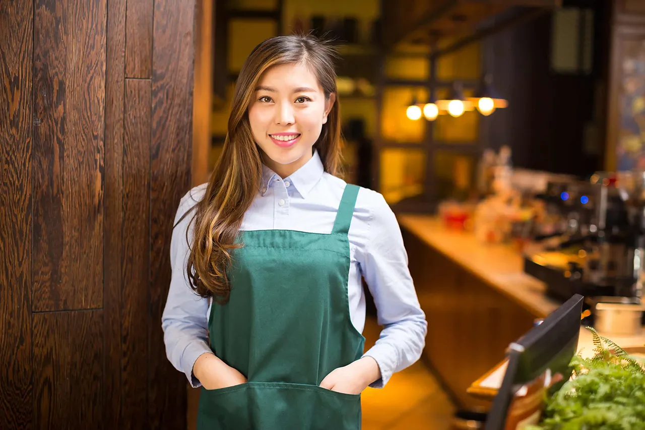 Female Asian waitress in apron