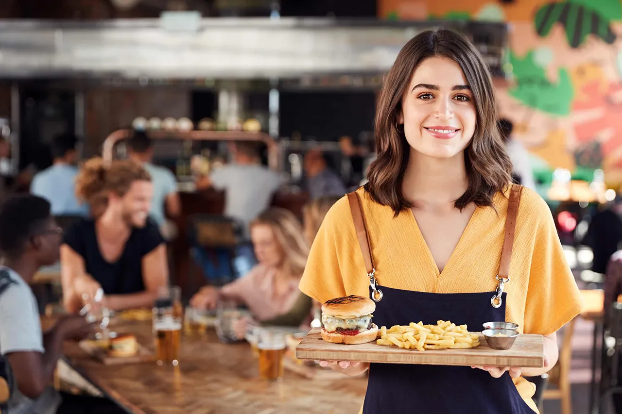 Female waitress holding food tray