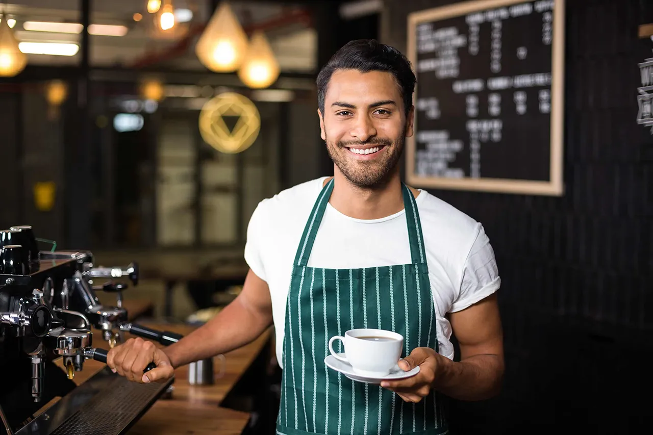 Male barista with a coffee cup